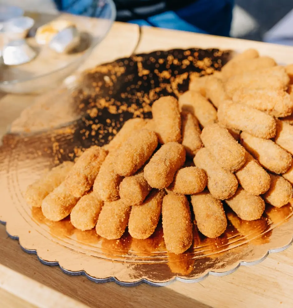 Travessa dourada com croquetes acabados de fritar